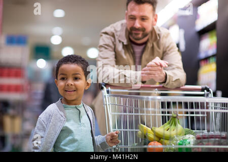 Padre e figlio facendo settimanale di negozio in negozio di alimentari Foto Stock