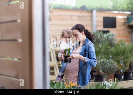 Donna incinta con la figlia al centro giardino Foto Stock