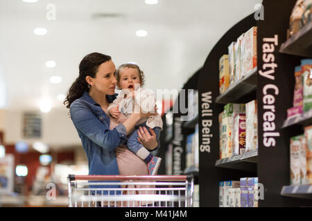 Donna incinta con la figlia a fare la spesa Foto Stock