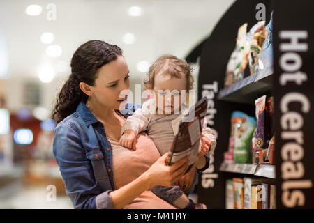 Donna incinta con la figlia a fare la spesa Foto Stock