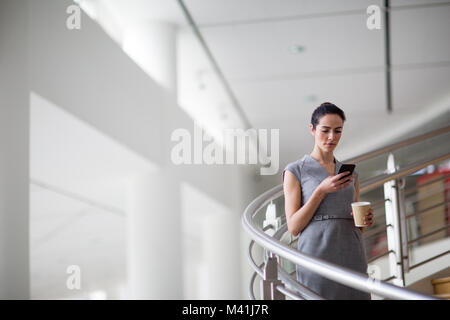 Imprenditrice utilizza lo smartphone app sul suo modo di lavorare Foto Stock