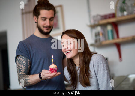 Fidanzato dando ragazza una tortina di compleanno Foto Stock