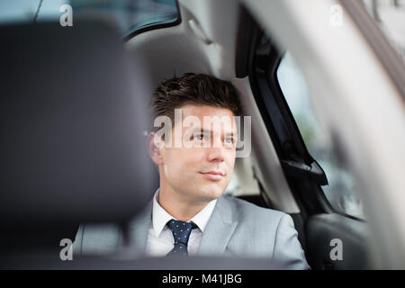 Imprenditore guardando fuori della finestra del taxi Foto Stock