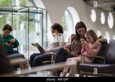 Le donne in attesa in un affollato ospedale sala di attesa Foto Stock