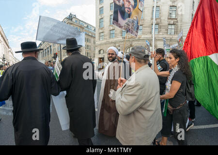 La linea di anti-sionista Neturei Karta ebrei e musulmani chierici, a fronte di Al Quds giorno marzo è stata seguita da persone che trasportano i cartelli e bandiere. Foto Stock