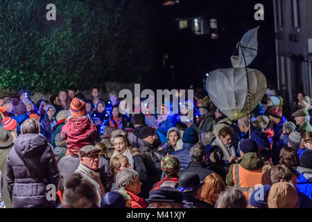 A forma di mela lanterna di carta portati dalla folla attraverso la strada a un wassail o tradizionale winter festival apple, Stoke Gabriel, Devon, Regno Unito. Jan 2018. Foto Stock