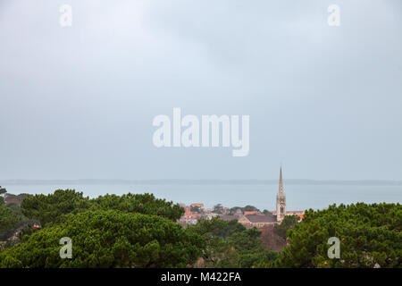 Vista aerea di Arcachon, Francia, durante una tempesta su un nuvoloso giorno piovoso, witht la basilica di Notre Dame di fronte. Situato nella baia di Arcachon (Bassin d'Arach Foto Stock