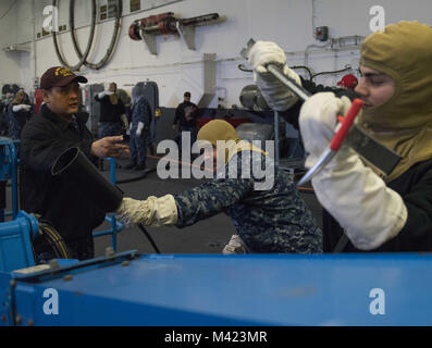 180208-N-KJ376-040 BREMERTON, nello Stato di Washington (Feb. 8, 2018) di aviazione di Boatswain Mate (manipolazione) 1a classe Jason Chapman, da San Diego, California, incarica i marinai a bordo degli aeromobili casualty danni procedura di controllo durante un quartier generale praticare nell'hangar bay di USS John C. Stennis (CVN 74). John C. Stennis è in porto la preparazione per la sua successiva installazione pianificata. (U.S. Foto di Marina di Massa lo specialista di comunicazione 2a classe Nick A. Grim / rilasciato) Foto Stock