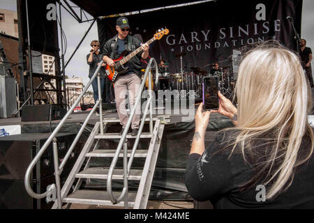 180210-N-IE405-1423 SAN DIEGO (feb. 10, 2018) una ventola prende una foto con star di Hollywood e musicista Gary Sinise e il tenente Dan banda in prossimità dello stadio al sesto convegno annuale invincibile spirito Festival. Il festival inoltre sono incluse le attività per i bambini, rock climbing, cibo cucinato da Team Irvine e 149 volontari che impostare e pietanze servite all'evento. Gary Sinise e il tenente Dan Band al debutto il loro primo concerto militare a NMCSD nel 2012. (U.S. Foto di Marina di Massa lo specialista di comunicazione 2a classe Indra Beaufort) Foto Stock