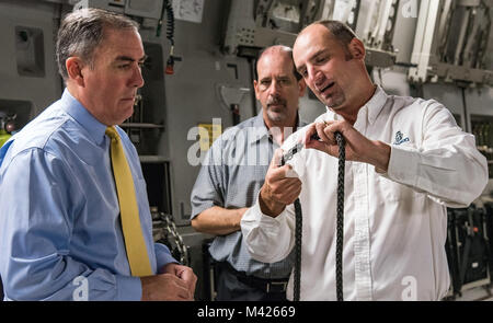 Justin Smoak, Samson corda application engineering manager, Ferndale, nello Stato di Washington, a destra mostra Roberto Guerrero, Vice Segretario Aggiunto della Air Force per energia operativa, sede U.S. Air Force, Washington D.C., a sinistra ed Ed Clark, AFRL programmi aeronautici contraente di supporto con Concurrent Technologies Corporation, Johnstown, Pa., la tessitura del verricello sintetico cavo, Sett. 6, 2017, alla Dover Air Force Base, Del. la proposta di 280-piede sintetico cavo del verricello pesa 14 chili ed è 83% più leggero rispetto alla corrente 80 libbra di filo in acciaio cavo. (U.S. Air Force Foto di Roland Balik) Foto Stock