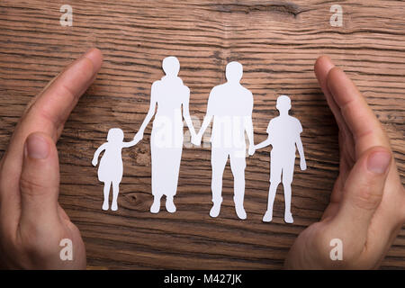 Elevato angolo di visione della persona lato della protezione della famiglia Papercut su legno Foto Stock