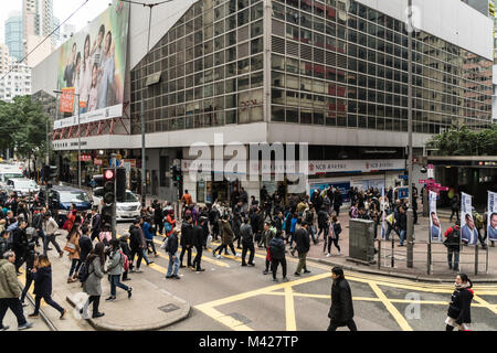 Hong Kong - 2 Febbraio 2018: persone attraversano la strada trafficata di fronte al Wanchai dalla stazione MRT in Isola di Hong Kong, Cina SAR Foto Stock