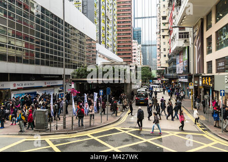 Hong Kong - 2 Febbraio 2018: persone attraversano la strada trafficata di fronte al Wanchai dalla stazione MRT in Isola di Hong Kong, Cina SAR Foto Stock