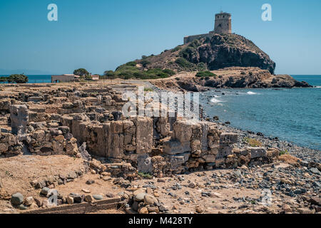 La torre di guardia e le antiche rovine romane e pre-romane della penisola di Nora. Famoso sito archeologico nei pressi di Cagliari, Sardegna, Italia. Foto Stock