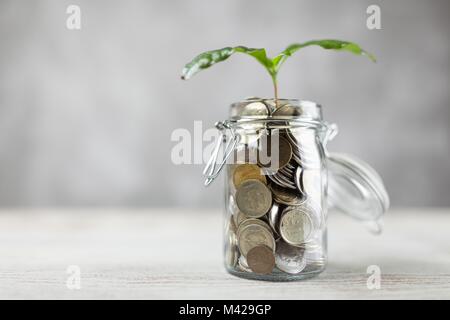 Monete in un vasetto di vetro Foto Stock