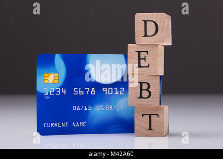 Close-up di carte di debito e di debito sul testo impilati blocco di legno Foto Stock