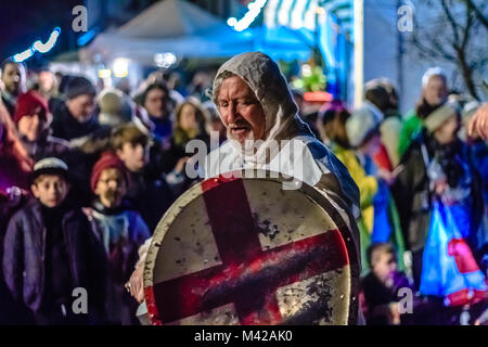 Attori in costume del cavaliere presso il village street festival a guardare la folla, di notte. Wassail festival di apple. Stoke Gabriel, Devon, Regno Unito. Gennaio 2018. Foto Stock