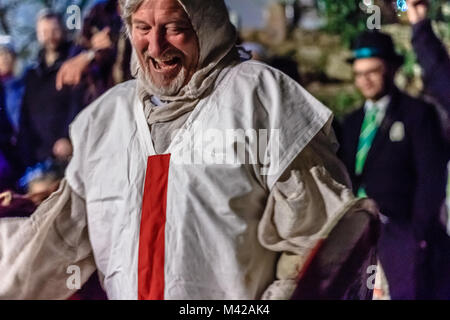 Attori in costume del cavaliere presso il village street festival a guardare la folla, di notte. Wassail festival di apple. Stoke Gabriel, Devon, Regno Unito. Gennaio 2018. Foto Stock