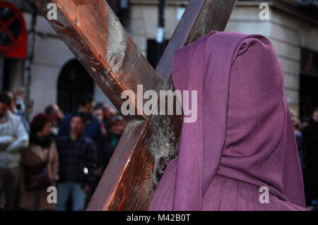 Penitente croce coperta in processione portando nella Settimana Santa a Madrid Foto Stock