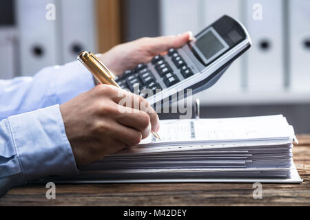 Close-up di un imprenditore la mano della fattura di calcolo con la calcolatrice Foto Stock