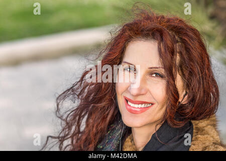 Donna rugosa con piedi di crow e capelli sul mento sorridente Foto Stock