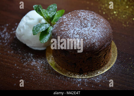 Fondan Dessert Cioccolato con menta e gelati su un bacground ligneo. Uno squisito cioccolato francese fondan dessert Foto Stock