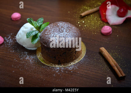 Fondan Dessert Cioccolato con menta e gelati su un bacground ligneo. Uno squisito cioccolato francese fondan dessert Foto Stock