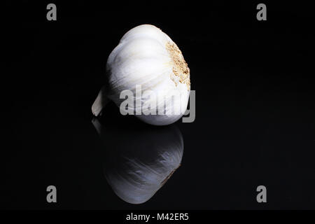 Aglio su riflettente nero di sfondo per studio. Isolato nero specchio lucido specchiato sfondo per ogni concetto.. Foto Stock