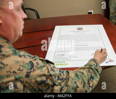 Stati Uniti Marine Corps Brig. Gen. Kevin J. Killea, Comandante Generale Marine Corps Impianti West, Marine Corps base Camp Pendleton, segni di un annuncio per militari settimana salva su Camp Pendleton, California, 8 febbraio 2018. Salva militare settimana è progettato per diffondere la consapevolezza finanziaria sulla creazione di ricchezza attraverso il risparmio di denaro e di riduzione del debito pubblico, mentre anche la focalizzazione sul nuovo miscelato sistema di pensionamento. (U.S. Marine Corps Foto Stock