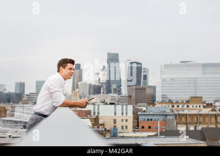 Imprenditore guardando a Londra dello skyline della città Foto Stock