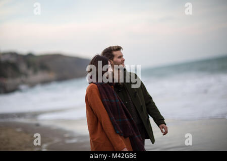 Giovane adulto giovane camminando sulla spiaggia Foto Stock