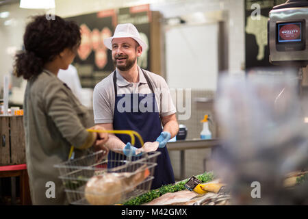 Cliente chiedendo pescivendolo per consulenza Foto Stock