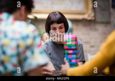 Gruppo di amici a giocare gioco retrò in pub Foto Stock