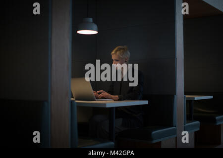 Imprenditrice a lavorare fino a tarda notte in ufficio da solo Foto Stock