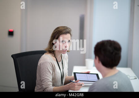 Donne Medico che spiega i risultati dei test per il paziente Foto Stock