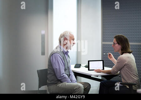 Donne Medico che spiega i risultati dei test per il paziente Foto Stock