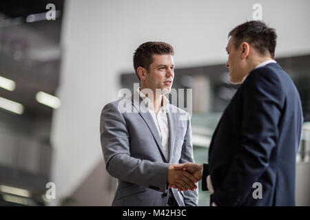 Imprenditori stringono le mani in un ufficio aziendale Foto Stock