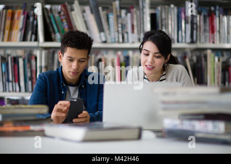 Gli studenti che lavorano insieme in biblioteca Foto Stock