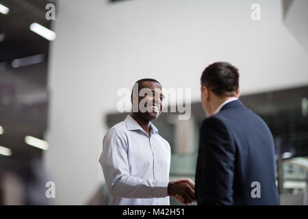 Imprenditori stringono le mani in un ufficio aziendale Foto Stock