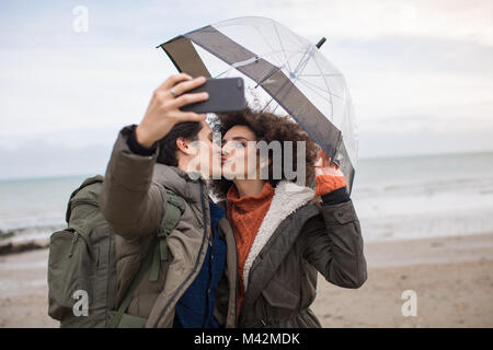 Coppia giovane prendendo un selfie baciare su una pausa invernale Foto Stock