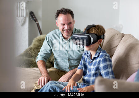 Boy utilizzando un auricolare VR gioco a casa Foto Stock