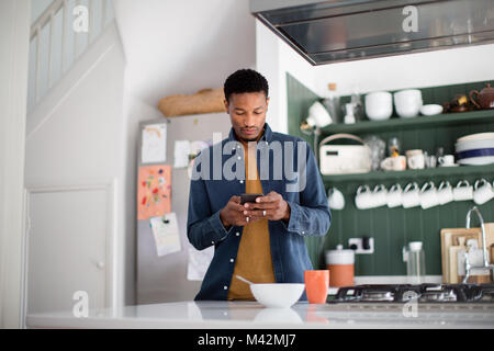 Americano africano controllo maschio telefono di mattina Foto Stock