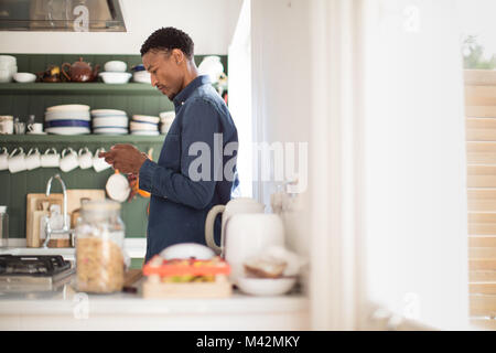 Americano africano controllo maschio telefono di mattina Foto Stock