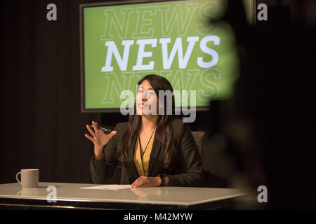 News presenter in un TV broadcasting studio Foto Stock