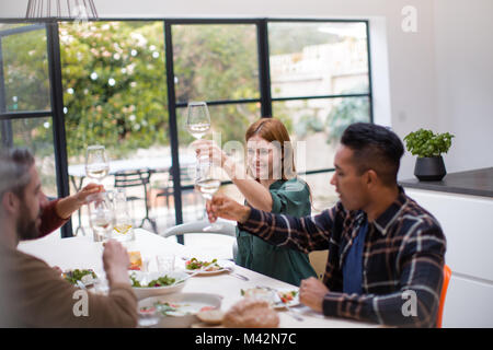 Amici bicchieri tintinnanti nel corso di un pasto insieme Foto Stock