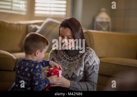 Madre e Figlio di unwrapping regali di Natale Foto Stock