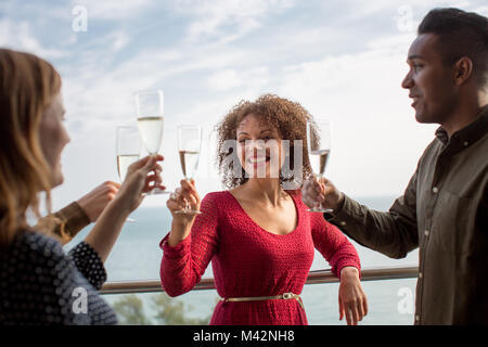 Amici godendo la vista dal balcone del mare Foto Stock