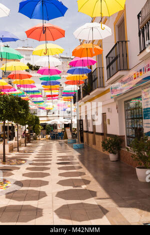 Una immagine di un tipico villaggio spagnolo in una calda giornata d'estate con la aggiunta di ombrelloni per creare un po' di ombra e l'area colorata. Foto Stock