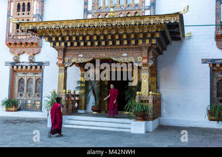Punakha, Bhutan. I Monaci buddisti nella porta di una zona residenziale di Punakha Dzong (fortezza/monastero). Foto Stock