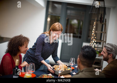 Femmina adulta che serve il pranzo di Natale per gli amici Foto Stock
